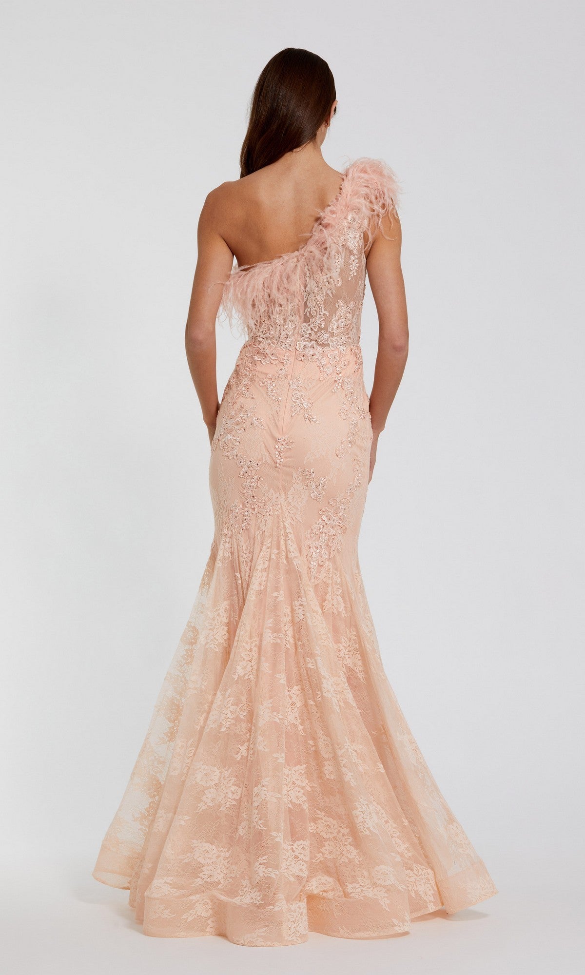 A woman faces away, wearing the Mac Duggal 79451 long formal dress—a peach, one-shoulder mermaid gown with lace details and feather trim accents.